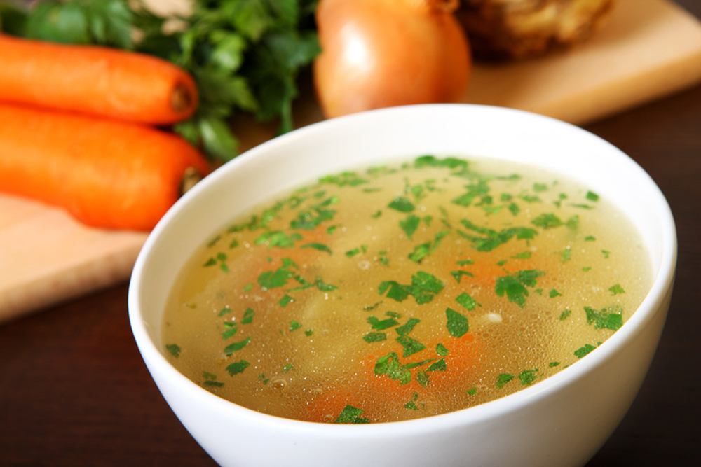 Bouillon de légumes sur table en bois