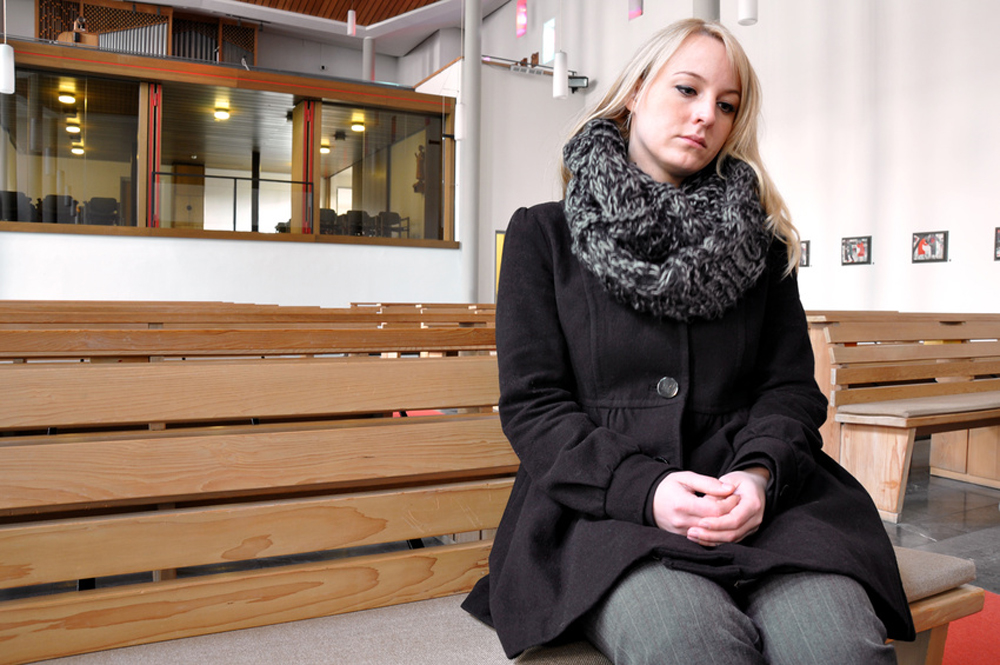 Femme avec écharpe assis sur un banc