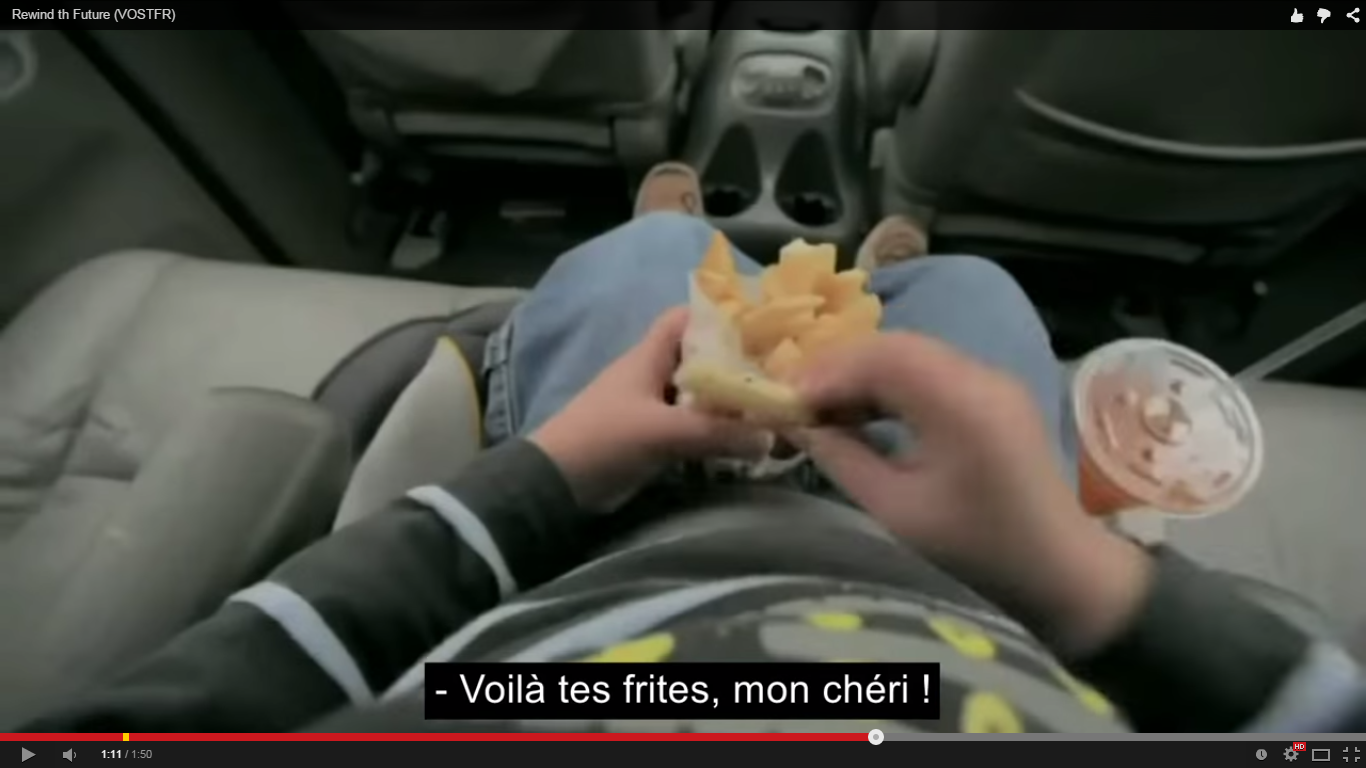 Enfant qui consomme des frites et un soda dans une voiture