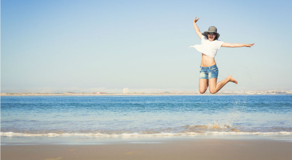 jeune femme qui saute sur la plage