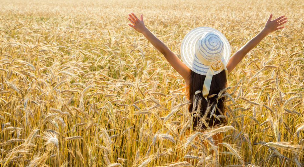 Femme écartant les bras dans un champ