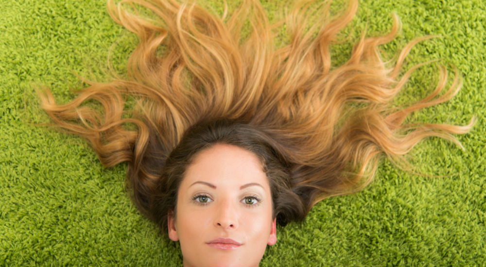 Femme allongée dans l'herbe, les cheveux dispersés