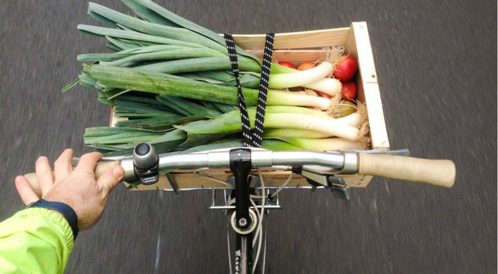 Livraison d'un panier de légumes avec des poireaux à vélo