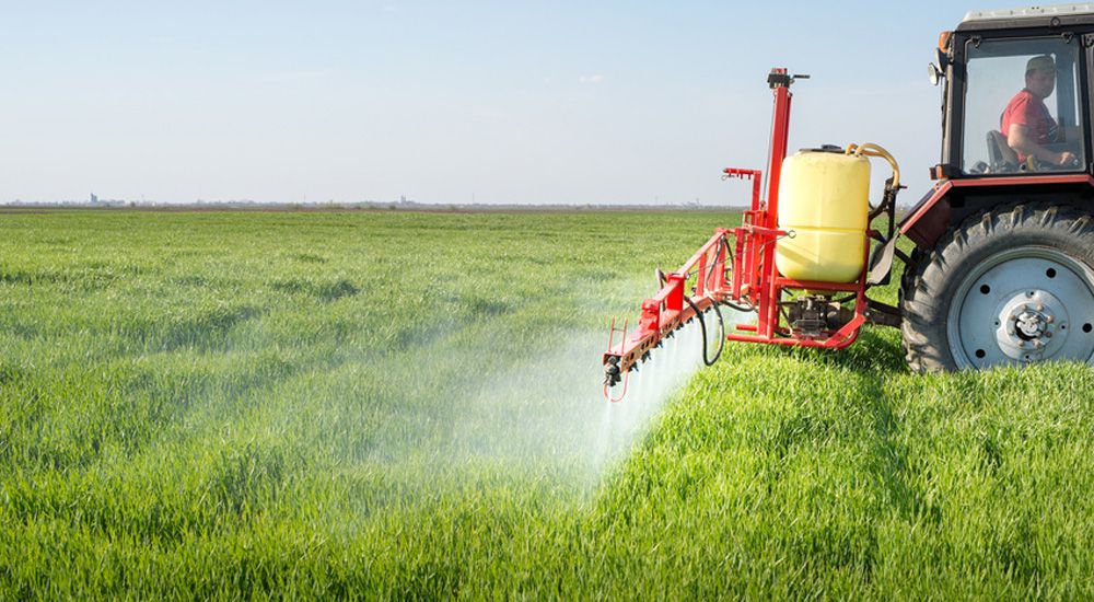 Tracteurs pulvérisant des pesticides dans un champ
