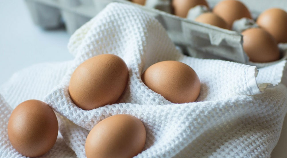 des oeufs sur un torchon sur une table avec une boite d'oeufs