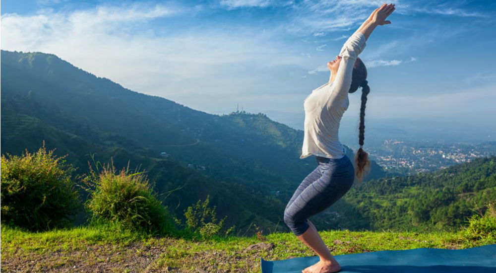 une femme fait du yoga à la montagne