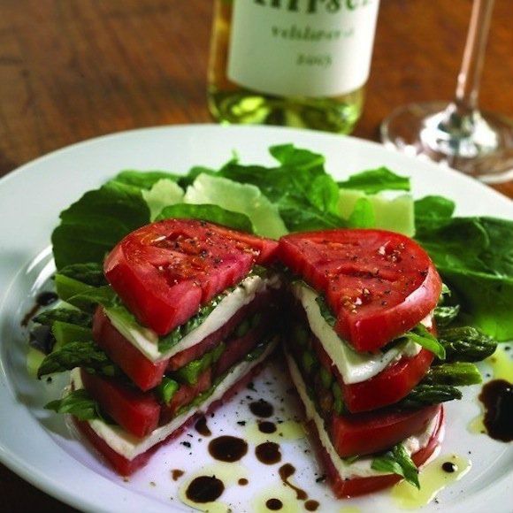 un swandich tomates, mozzarella, asperges et salade dans une assiette blanche