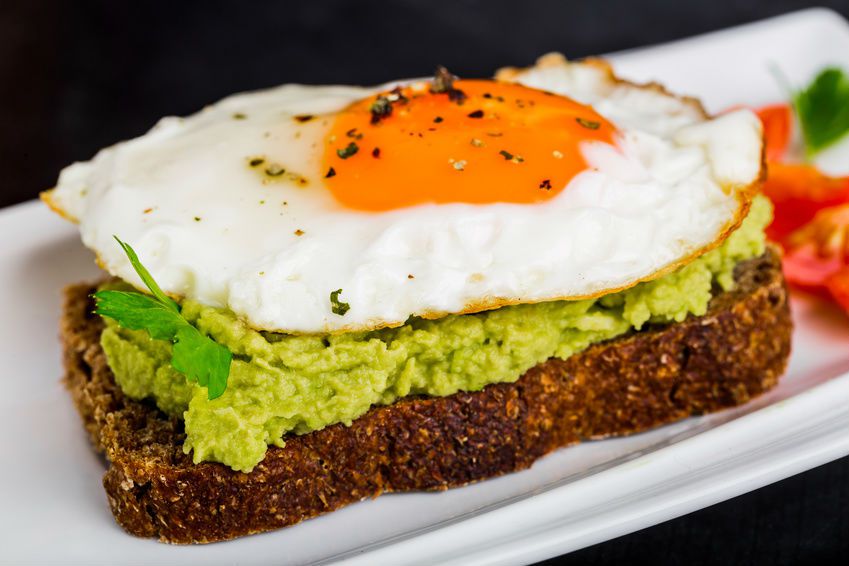 Une tartine de pain avec de l'avocat et un œuf au plat