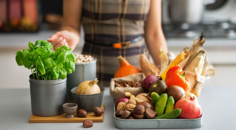 une femme cuisine des fruits et légumes