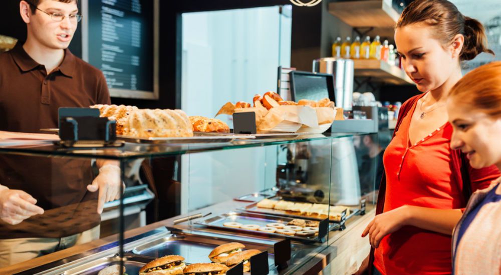 une mère et sa fille regardant les produits d'un boulanger