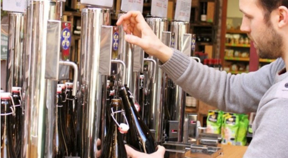un homme remplit une bouteille en verre