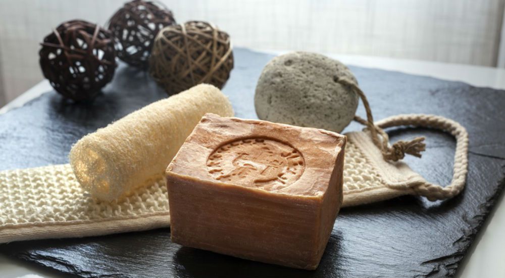 du savon noir posé à coté d'un loofah et de quelques accessoires de beauté utilisé dans les hamam