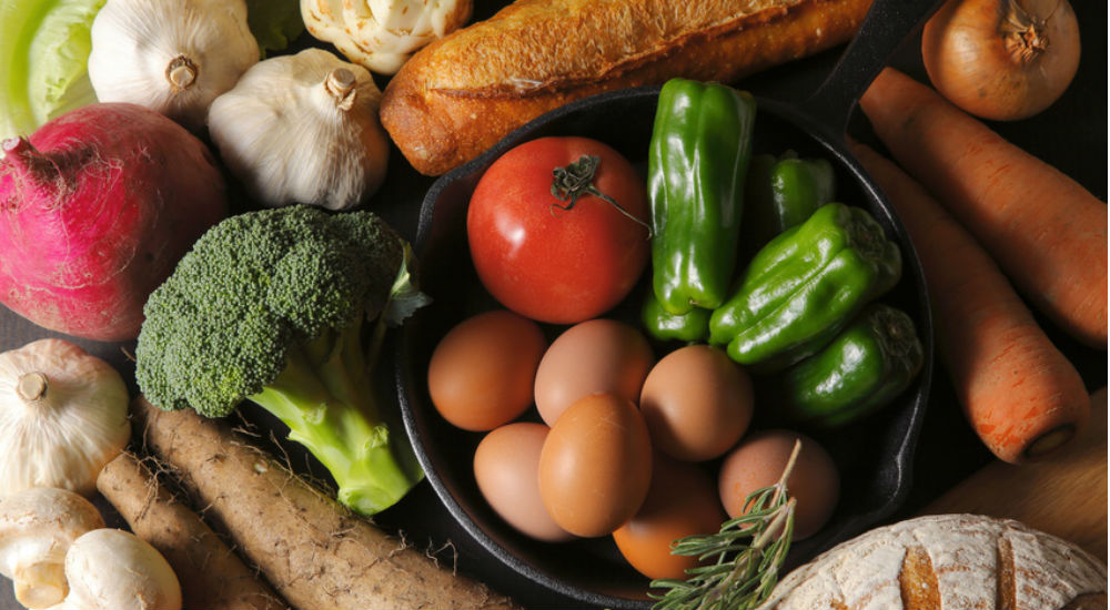 des fruits, des légumes, du pain sur une table