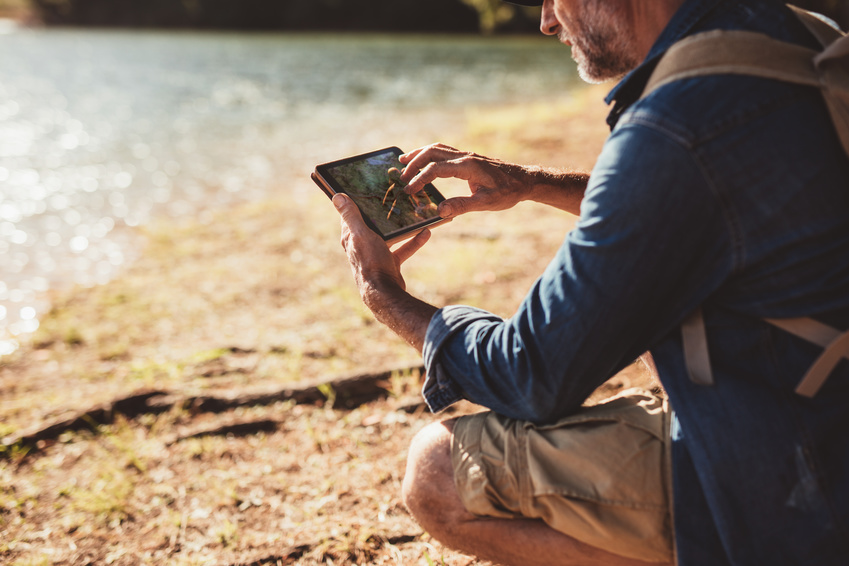 Un homme dans la nature tenant un smartphone