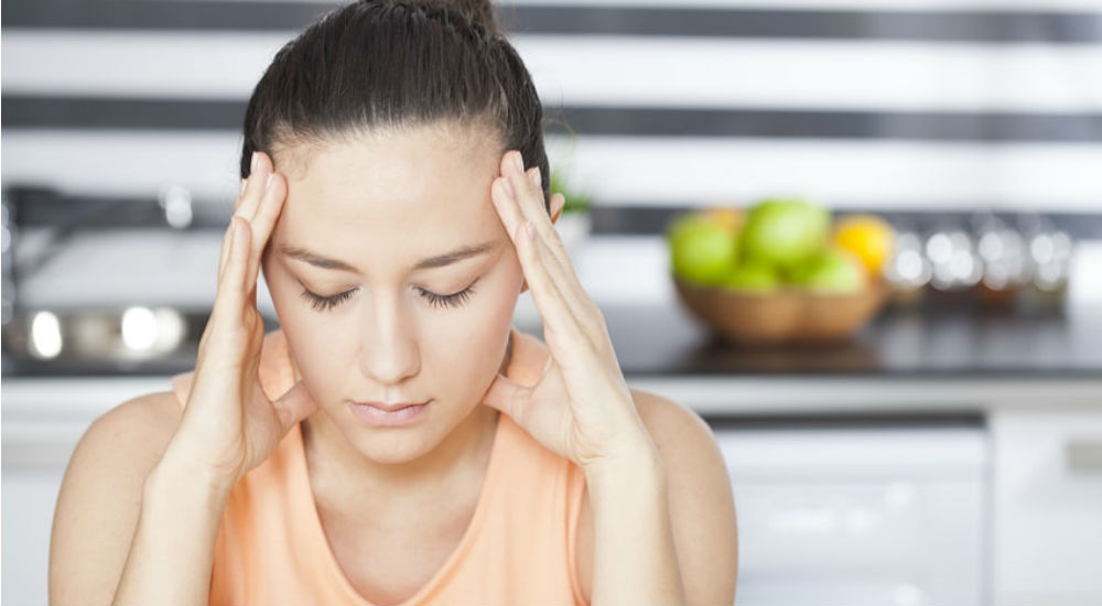 une femme est sujette aux maux de têtes