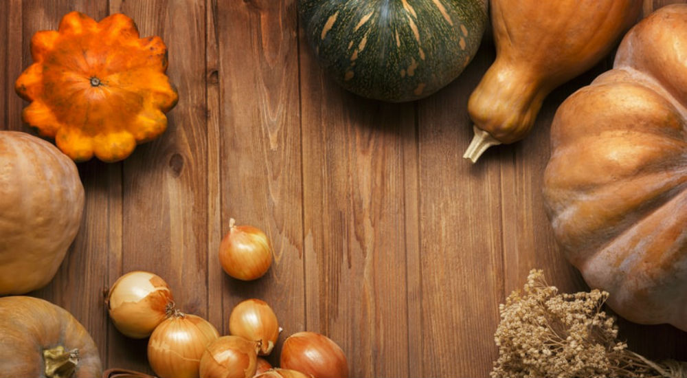 de l'oignon, de la courge, du potiron sur une table aux couleurs de l'automne