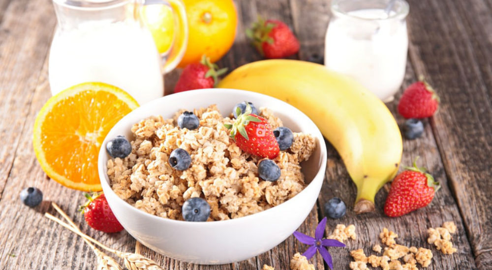 un petit déjeuner avec un bol de muesli et des fruits