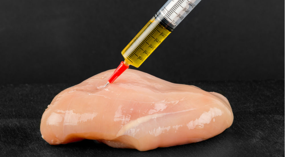 une viande piquée avec une seringue d'antibiotiques