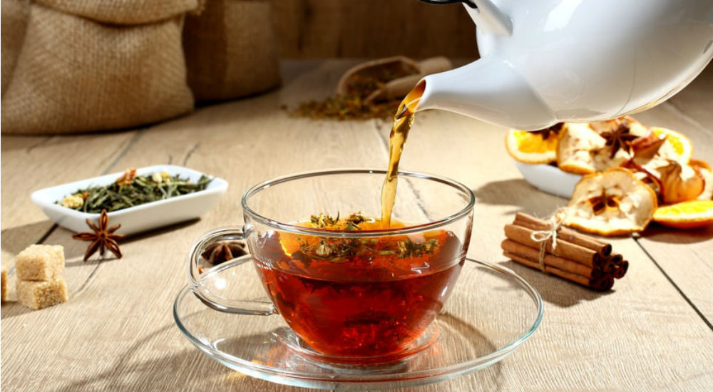 une théière verse une tisane digestive dans une tasse