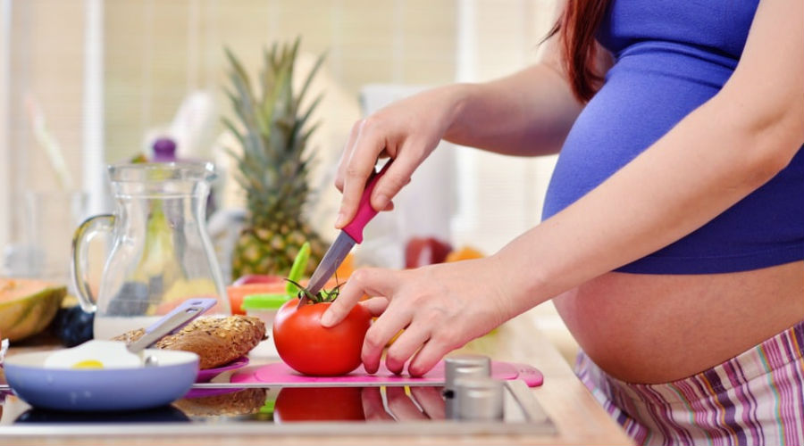 une femme enceinte fait la cuisine