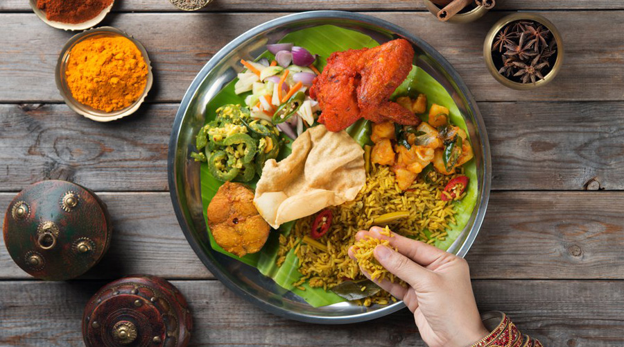 Une personne mange avec les doigts un plat indien
