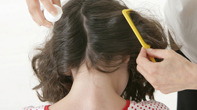 Une maman peigne une petite fille qui a des poux